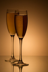 A glass of champagne, isolated on a yellow background.