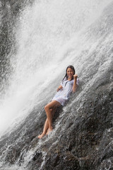 Mädchen sitzt im Wasserfall