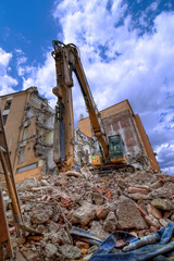 Fototapeta premium Escavatore con palazzi in demolizione