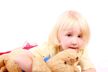 Blondes M&auml;dchen kuschelt mit Teddy
