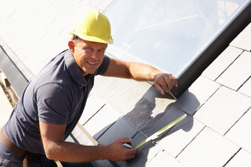 Roofer Working On Exterior Of New Home - obrazy, fototapety, plakaty