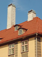 Red roof with tall white cimney and dormers