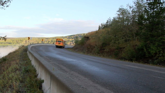 school bus climbing hill and going around a corner