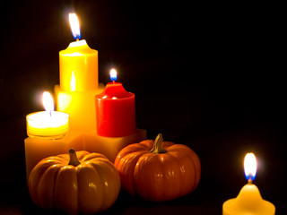 Mini Pumpkins and Candles with a Black Cloth Background