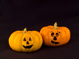 Mini Pumpkins with Funny Faces with a Black Cloth Background