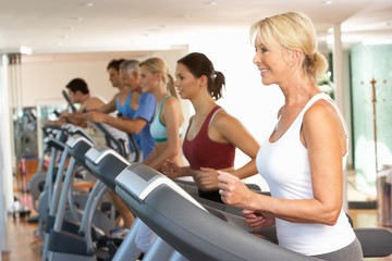 Fototapeta na wymiar Senior Woman On Running Machine In Gym