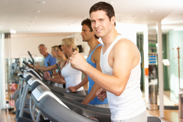 Fototapeta na wymiar Man On Running Machine In Gym