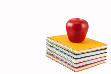Red apple placed on the top of note book