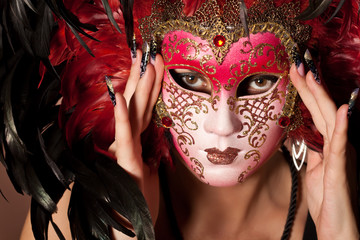 Woman with beautiful manicure on long finger hold venetian mask