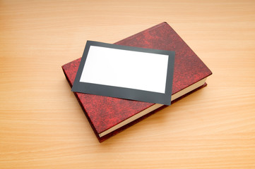 Books and blank photos on wooden table