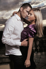 Naklejka premium Beautiful couple hugging over cloudy sunset