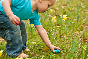 Fototapeta na wymiar Closeup of toddler picking Easter eggs on an Easter egg hunt