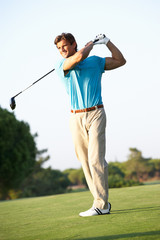 Male Golfer Teeing Off On Golf Course