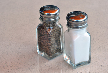 A salt and pepper shakers on a marble table