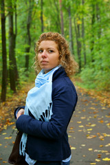 Young blonde woman on the road in autumn park