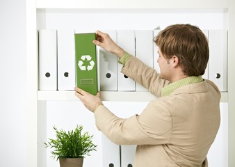 Man drawing out green folder