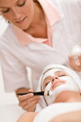 Woman at spa getting facial mask