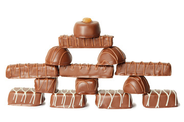 many chocolate appetizing candys with icing pyramid figure