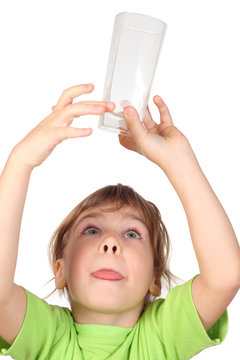 Little Girl In Green Shirt Holding Empty Glass Over Her Head