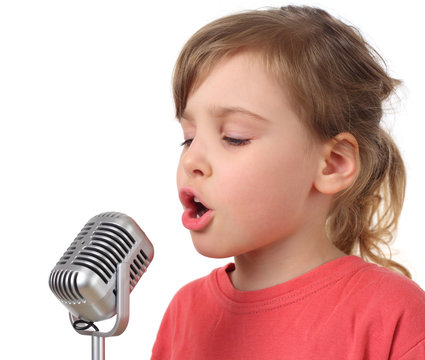 little girl in red shirt singing in microphone, half body