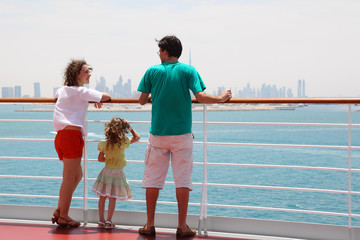 family with daughter standing on cruise liner deck