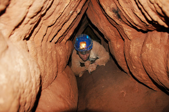 Caver in a narrow passage