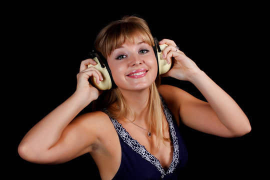 a charming young blonde on a black background with earphones