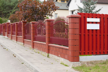 The red fence is located in rural street