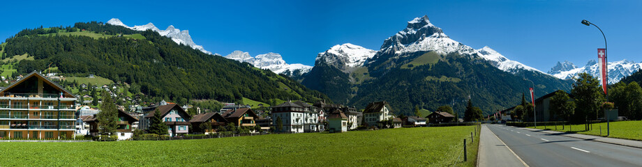 Fototapeta na wymiar Swiss village, road and alpine mountains