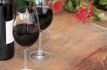 Bottle & Glasses Red Wine on Outdoor Table with Pohutukawa