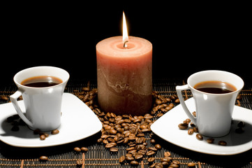 Two cups of the coffee and candle on the table.