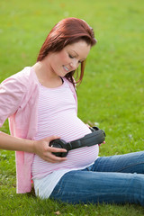 Merry pregnant woman with headphones on her belly