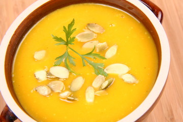 Bowl of pumpkin soup on wooden background