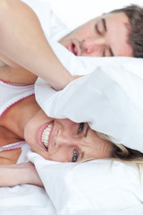 stressed woman lying on the bed with her boyfriend snoring