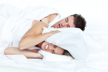 Couple in bed while the woman is trying to sleep