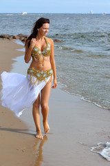 Beautiful young girl walking on beach