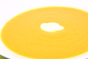 Pumpkin Soup decorated with cream on white background