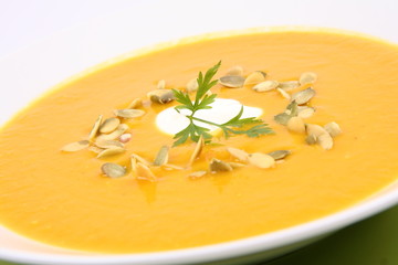 Pumpkin Soup decorated with cream, pumpkin seeds and parsley