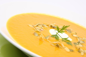 Pumpkin Soup decorated with cream, pumpkin seeds and parsley