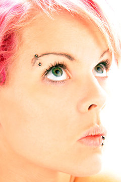 Eine Frau mit grünen großen Augen und Piercing