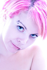 Eine Frau mit rosa Haaren und Piercings im Gesicht