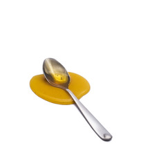 Honey on a spoon over a white background