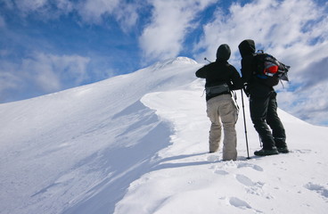 couple admiring mountain top in winter, julijan alps