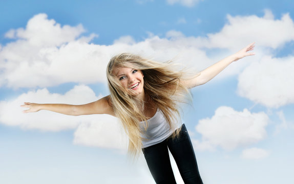 young happy girl flying on sky background