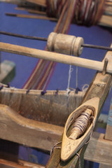 Closeup of vintage wooden weaving spindle on knitting loom