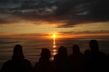 Menschengruppe beobachtet den Sonnenuntergang
