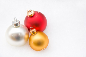 Weihnachtskugeln im Schnee, gold, silber, rot