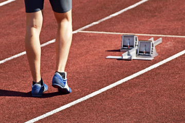 View of athlete's legs in blue shoes minutes before start.