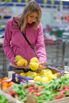 Beautiful young woman shopping for fruits and vegetables in prod