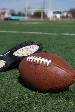 American football and cleat on the field